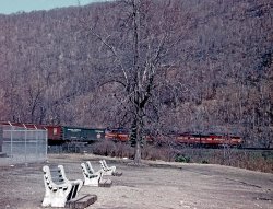 My Dad wasn't really a train fan, so to speak, but we're genetically disposed to appreciate transport in its many guises.
He roamed western Pennsylvania as a field director for the Presbyterian Church and on one of his trips in February 1960, he made a stop at the Horseshoe Curve and recorded this express train headed to points east.
Photographer Don Hall, Sr.
Don Hall
Yreka, CA
Pennsy E&#039;sWhen I worked for Conrail in the early 80s, I had the opportunity to ride from Pittsburgh to Altoona on the head end of a freight train.  Went by this spot and took pictures of people taking pictures of my train!
Coming &#039;round the CurveThat's not an express train but a freight train, and right behind the diesel locomotives (looks like two A - or cab - units and two B - all engine - units) are a Railway Express box car and one with the Pennsylvania Railroad logo (PRR in a keystone, because Pennsylvania is the Keystone State). 
I grew up in Altoona and the world famous (and it was) Horseshoe Curve was maybe 20 minutes from town. My dad, who retired from the Pennsylvania Railroad after 38 years, used to take us kids in the 1940s and 1950s there to climb the steps up to the track level, where you could stand (with no fence, I think) and experience America's railroad traffic closeup in its glory years. 
The road to the Curve continued on through a culvert under the track right-of-way, and beyond that culvert the shallow mountain stream that bordered it had a low bank where lots of people would drive their cars into the water to wash them. I can still see all those soap suds (and various engine drippings, I'm sure) going through the culvert and on their way to the Altoona Reservoir. No one gave it an environmental thought. Nor did anyone seemed to be bothered by the deer and other wildlife that drowned in our city's water supply. But I'm sure it all was treated. Well, I hope it was.            
(ShorpyBlog, Member Gallery)